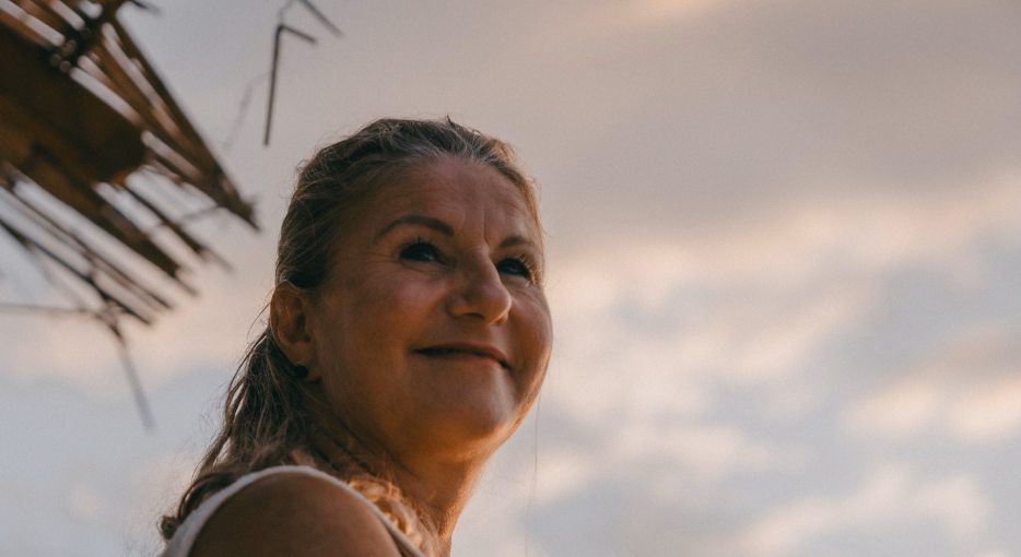 Lächelnde weise Frau am Strand 
