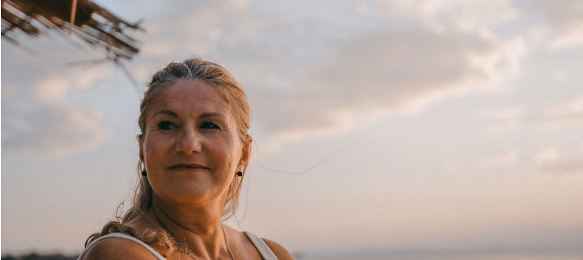 Lächelnde weise Frau am Strand